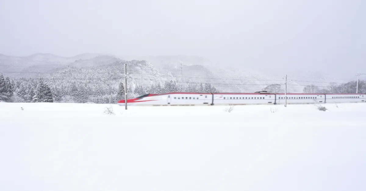 Ein Akita Shinkansen pflügt sich durch den Schnee in der Nähe der JR Tazawako Station