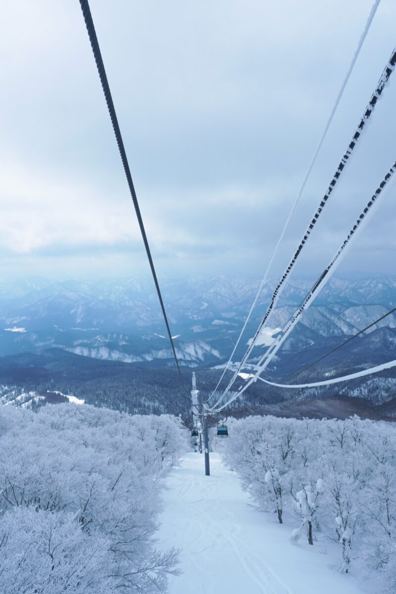 Blick aus der Seilbahngondel auf einen stark verschneiten Nadelwand unterhalb des Gipfels von Mount Moriyoshi