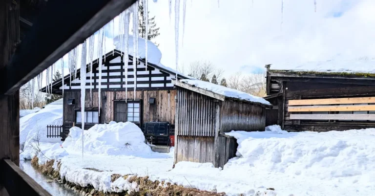Blick aus einer Hütte im Tsurunoyu Onsen auf einen winterlichen Fluss mit Eiszapfen